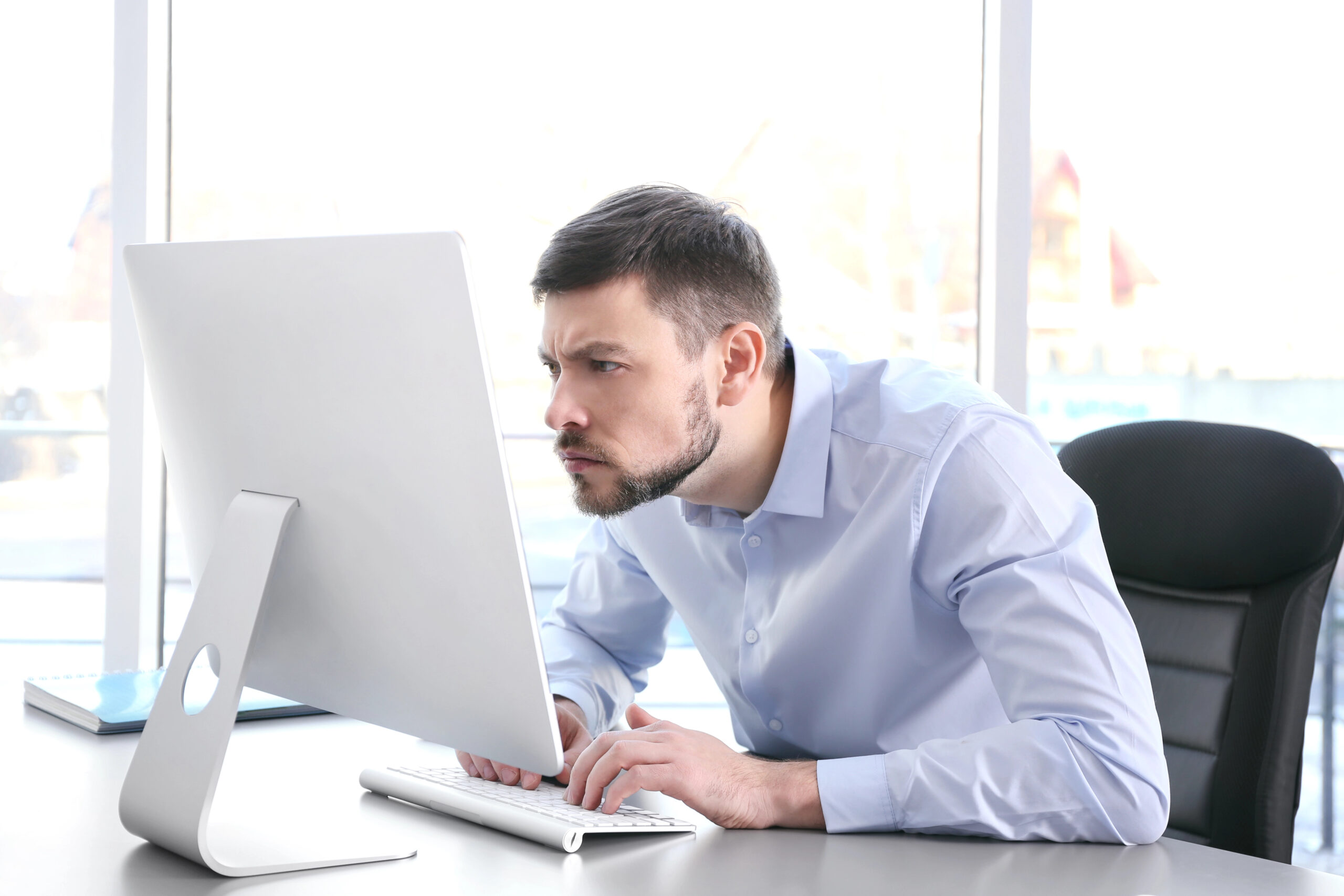 Man with forward head posture leaning toward computer screen